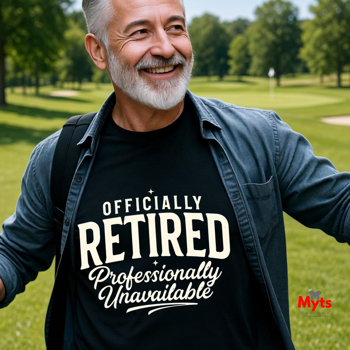 A smiling older man outdoors on a golf course wearing a black graphic T-shirt with white text that reads 'OFFICIALLY RETIRED Professionally Unavailable.' The shirt is layered under a dark blue button-up shirt, and a small 'Myts' mark appears in the lower right corner.