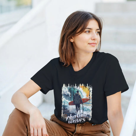 Woman wearing a black t-shirt with a graphic design sitting outdoors.