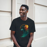 A man wearing a black t-shirt with a colorful graphic of a wolf and a full moon, standing against a light beige wall.