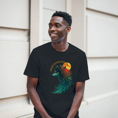 A man wearing a black t-shirt with a colorful graphic of a wolf and a full moon, standing against a light beige wall.