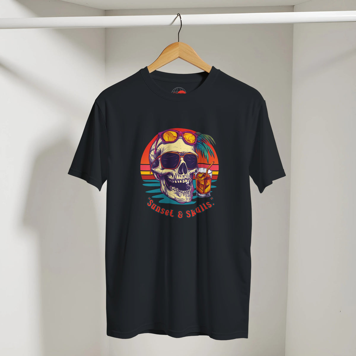 Black t-shirt with colorful skull design on a hanger against a white wall