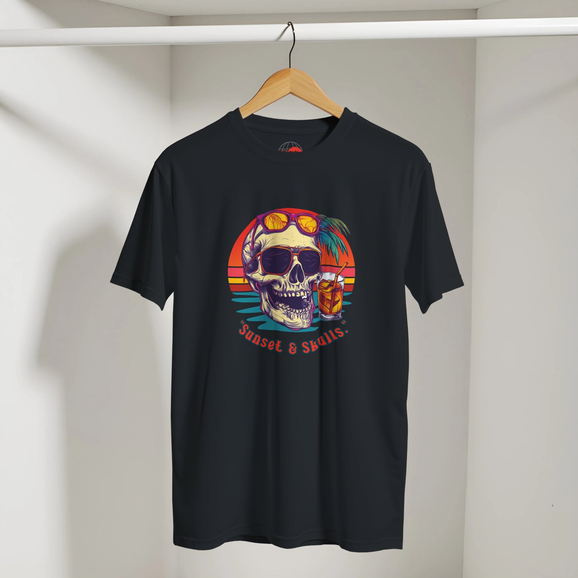 Black t-shirt with colorful skull design on a hanger against a white wall