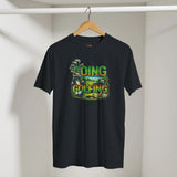 Black t-shirt with colorful golf-themed design on a hanger against a white wall.