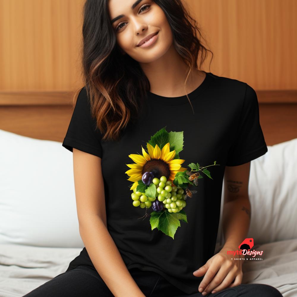 Woman wearing a black t-shirt with a sunflower and fruit design, sitting on a couch.