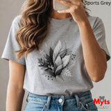 Person wearing a gray t-shirt with leaf design, taking a selfie.