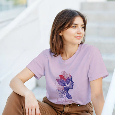 Woman wearing a purple t-shirt with a floral design, sitting outdoors.