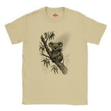 A Sand crewneck t-shirt featuring a detailed graphic print of a koala sitting on a tree branch with eucalyptus leaves. The shirt is displayed flat against a clean white background, with the red 'Myts' brand logo visible inside the collar.