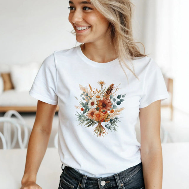 A woman wearing a white t-shirt with a floral design in a bright room.