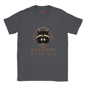 A dark heather gray crewneck t-shirt featuring a graphic of a raccoon inside a gold circle with the text 'R RACCOON Clever - Bold - Adaptable' printed below it.