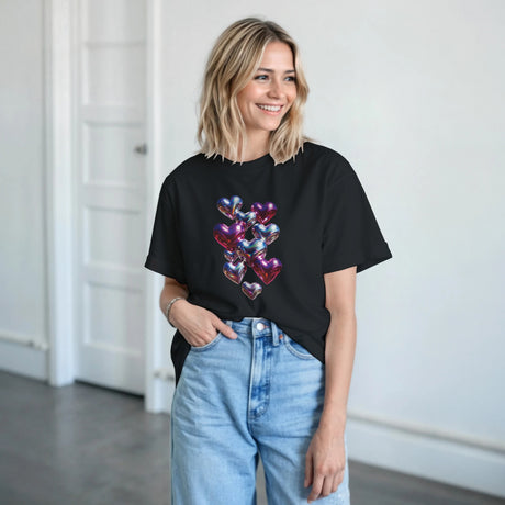 A woman wearing a black t-shirt with a heart design, standing indoors.