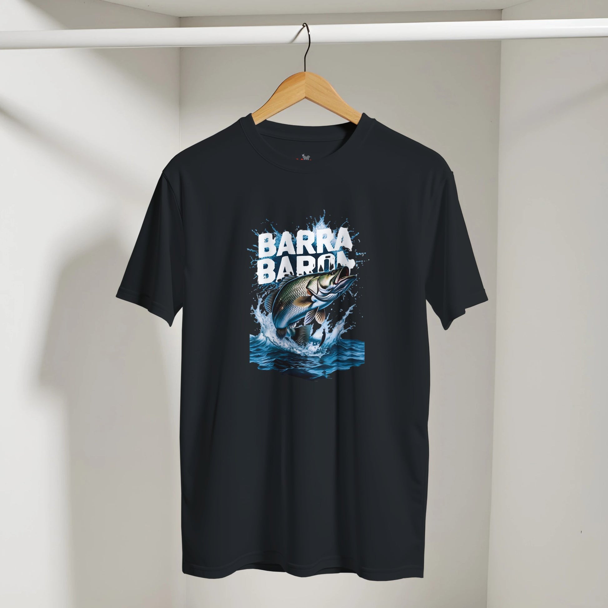 Black t-shirt with a fish graphic and 'Barra Barra' text on a hanger against a white wall.