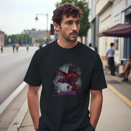 A Man wearing a black t-shirt with a colorful raven design on a city street.