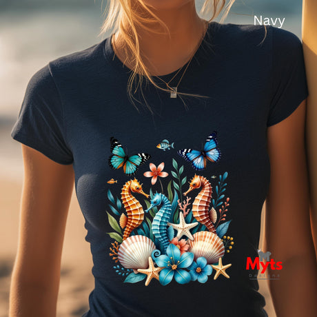 A woman wearing a black t-shirt with seahorses and butterflies, blurred beach background