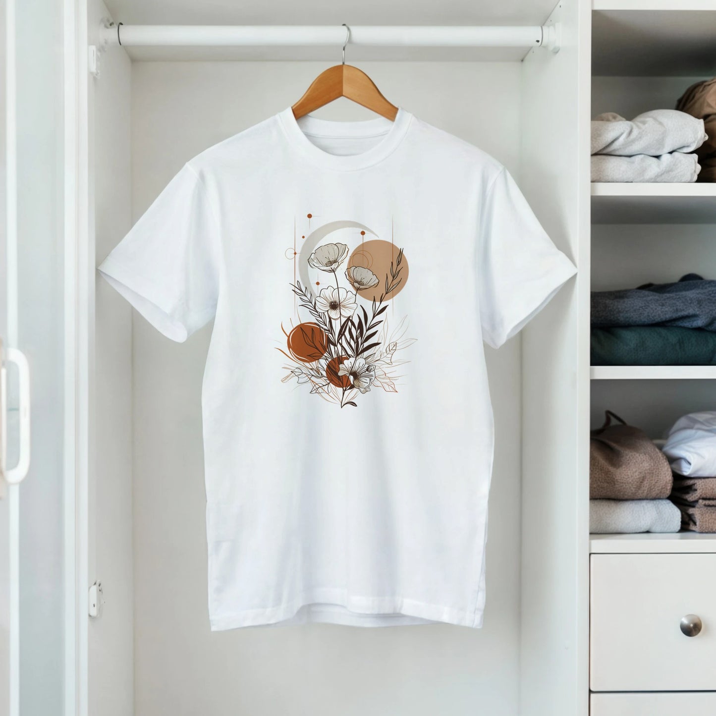 White t-shirt with floral design on a hanger in a closet