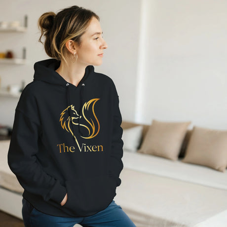 Person wearing a black hoodie with Gold fox vixen design in a room.