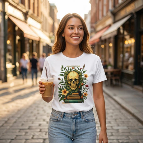 Woman wearing a white t-shirt with a skull design, holding a drink on a street.
