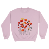 A Pink sweatshirt featuring a minimalist poppy flower design. The graphic displays red, orange, and muted gold poppies with slender stems and leaves, and the word “POPPiES” printed beneath. The cozy, casual outfit has a soft, modern aesthetic ideal for floral and nature-inspired fashion.