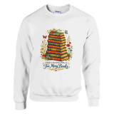 White sweatshirt featuring vintage stacked books artwork with floral accents and “There’s No Such Thing As Too Many Books” text.