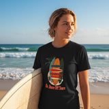 Person wearing a black t-shirt with a graphic design on a beach