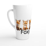 A white ceramic latte mug featuring three cute orange-red fox illustrations and the partial text 'Foxy' printed on the front, set against a clean white background.