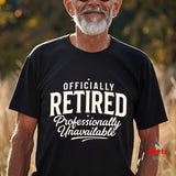 A man wearing a black t-shirt with the text 'OFFICIALLY RETIRED Professionally Unavailable' printed in white. The background is a warm, blurred outdoor setting.