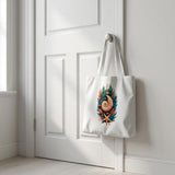 A white canvas tote bag with a colorful seashell and starfish graphic hangs from a white door in a bright, sunlit room.