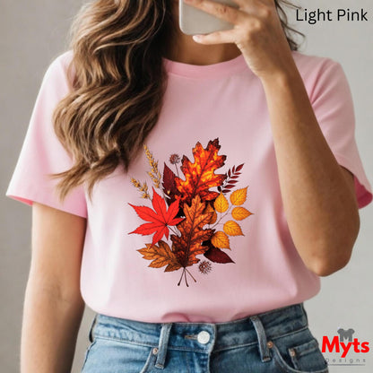 Person wearing a pink t-shirt with autumn leaf design, holding a phone.