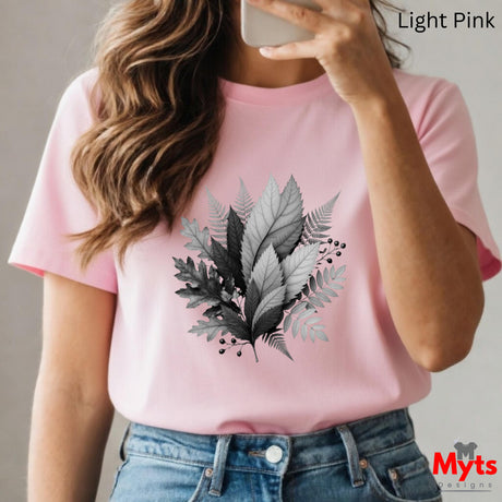 Person wearing a pink t-shirt with a leaf design, holding a phone.