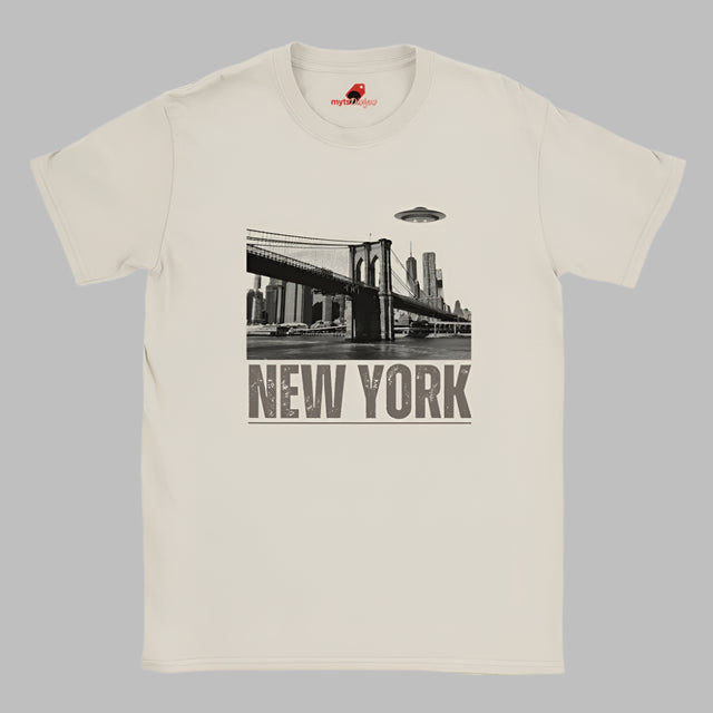 Sand colored soft casual tee showing the New York City skyline with a stylized spaceship graphic soaring above, printed on ultra-soft Gildan 64000 cotton.