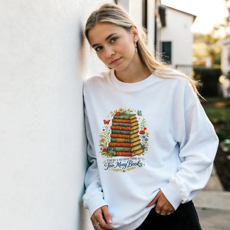 Woman wearing a white sweatshirt with a colorful book design and text.