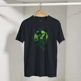 Black t-shirt with green graphic design on a hanger against a white wall