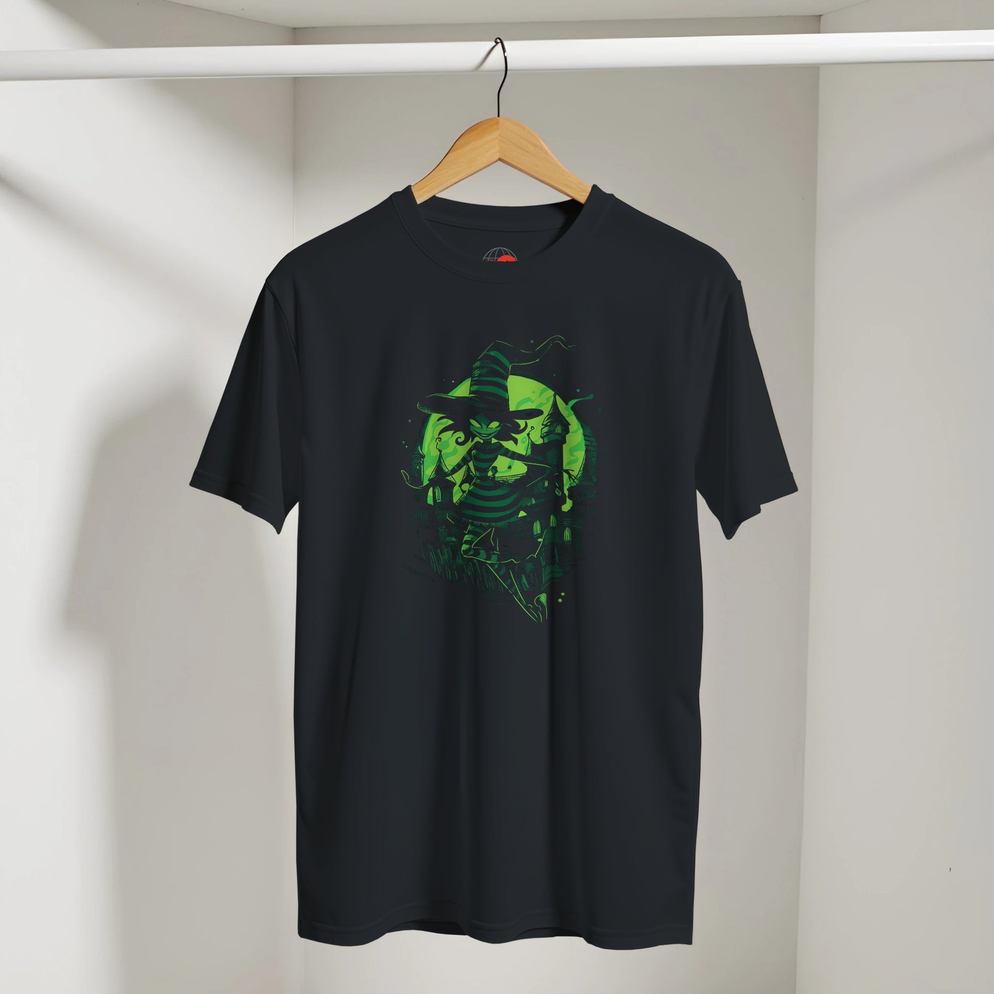 Black t-shirt with green graphic design on a hanger against a white wall
