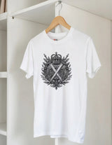 White t-shirt with black graphic design on a hanger against a white wall.