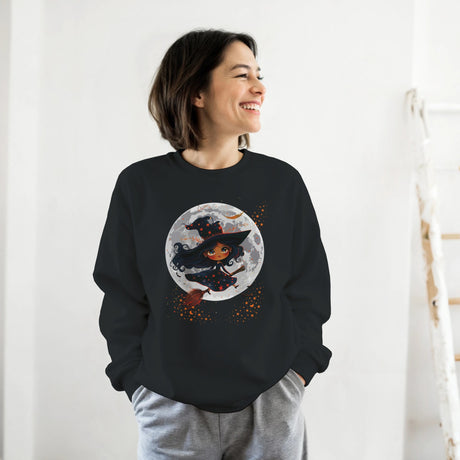 Person wearing a black sweatshirt with a Halloween-themed design of a witch and moon.