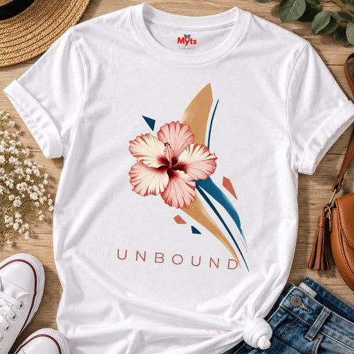 White UNBOUND hibiscus graphic T-shirt with pink floral artwork, styled flat with denim jeans, white sneakers, straw hat and sunglasses.