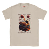 Natural t-shirt with a graphic design of books, roses, and candles on a white background.