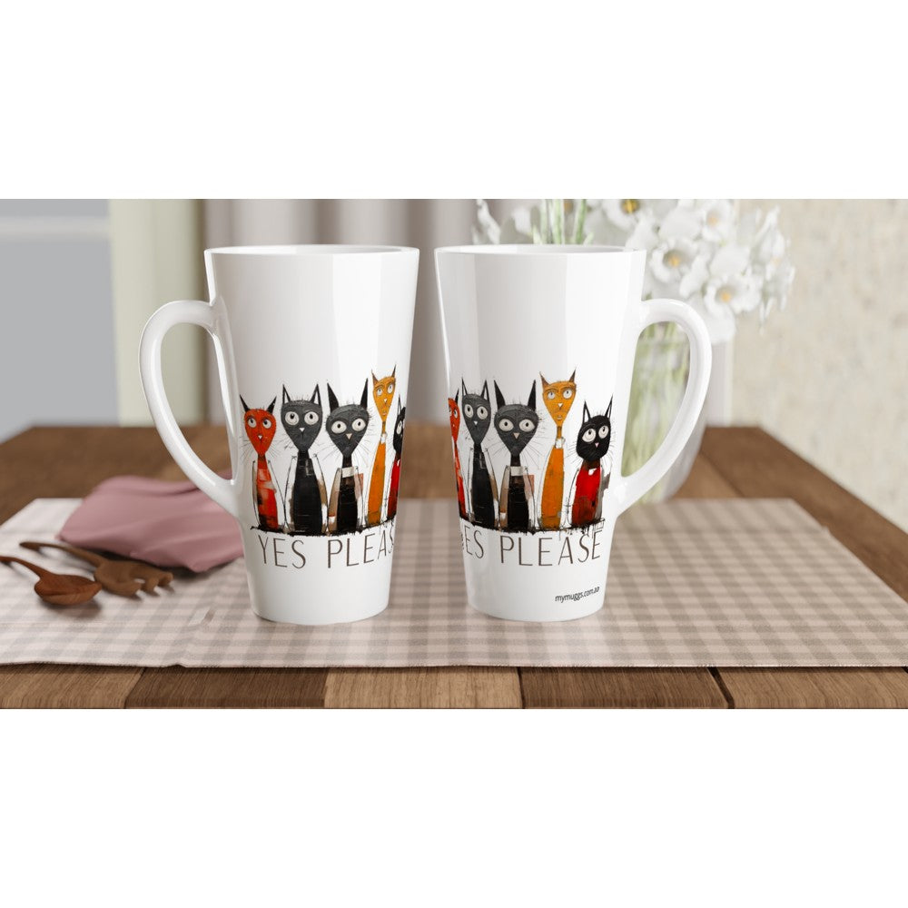 Two white ceramic latte mugs with handles, featuring a graphic of black, orange, and red cats wearing suits and the text 'YES PLEASE' printed below, displayed on a checkered placemat on a wooden table.