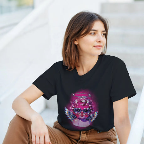 Woman wearing a black t-shirt with a colorful graphic design sitting outdoors.