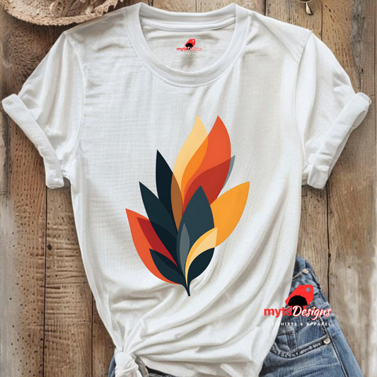 White t-shirt with colorful leaf design on a wooden surface, featuring mytsDesigns branding.