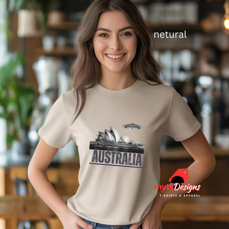 Front view of a young woman wearing a Netural colored soft casual tee showing the Sydney Opera House sails with a sleek spaceship graphic orbiting overhead, printed on ultra-soft Gildan 64000 cotton.T-shirt