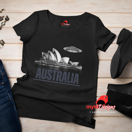 Front flat lay view of a black soft casual tee showing the Sydney Opera House sails with a sleek spaceship graphic orbiting overhead, printed on ultra-soft Gildan 64000 cotton.T-shirt