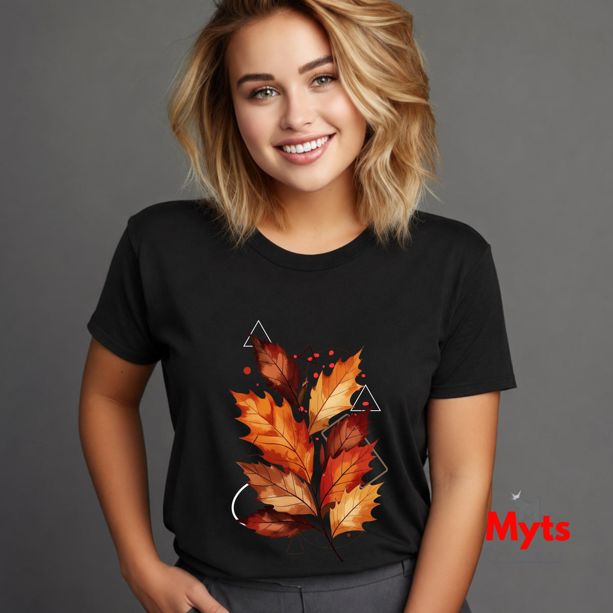 A woman wearing a black short-sleeve t-shirt with a graphic of autumn leaves in orange, red, and yellow, set against a solid gray background.