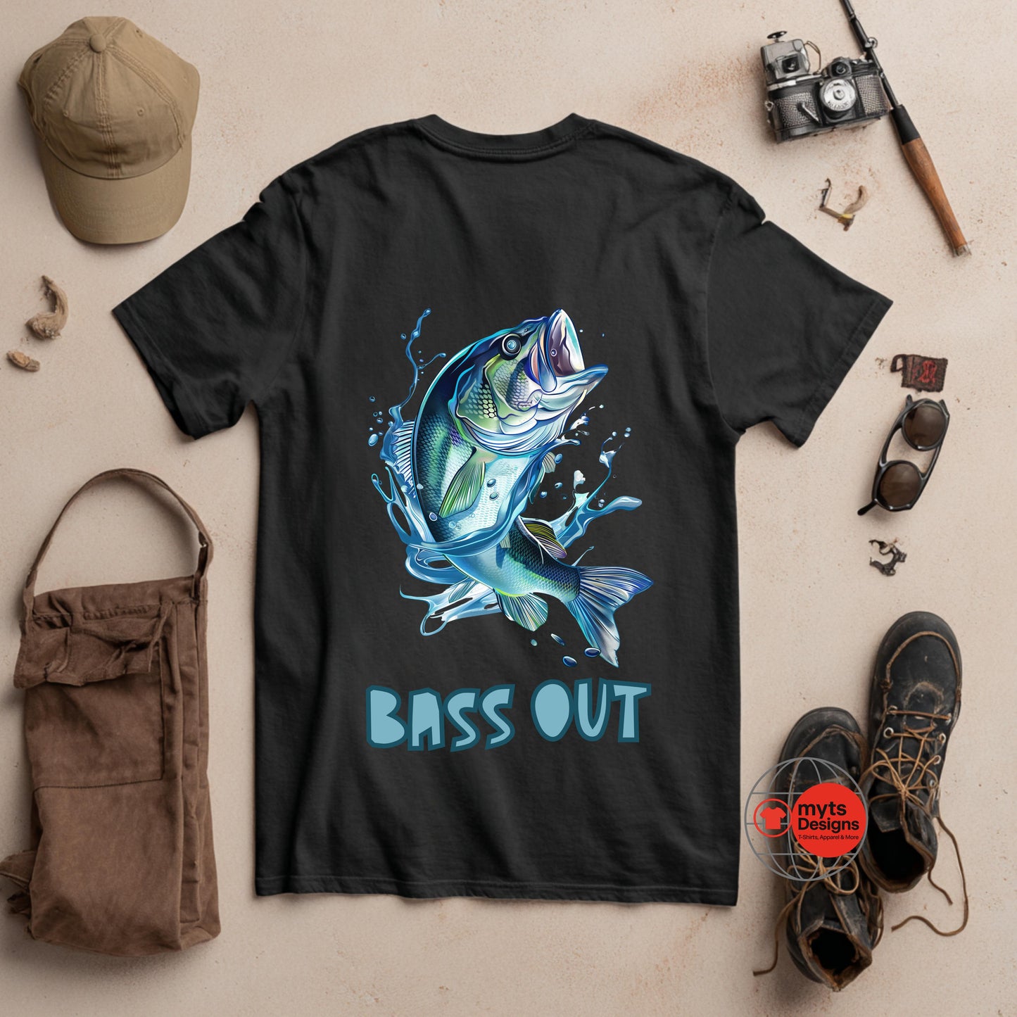 Black t-shirt with a blue fish graphic and 'BASS OUT' text, surrounded by fishing-themed items on a beige background.