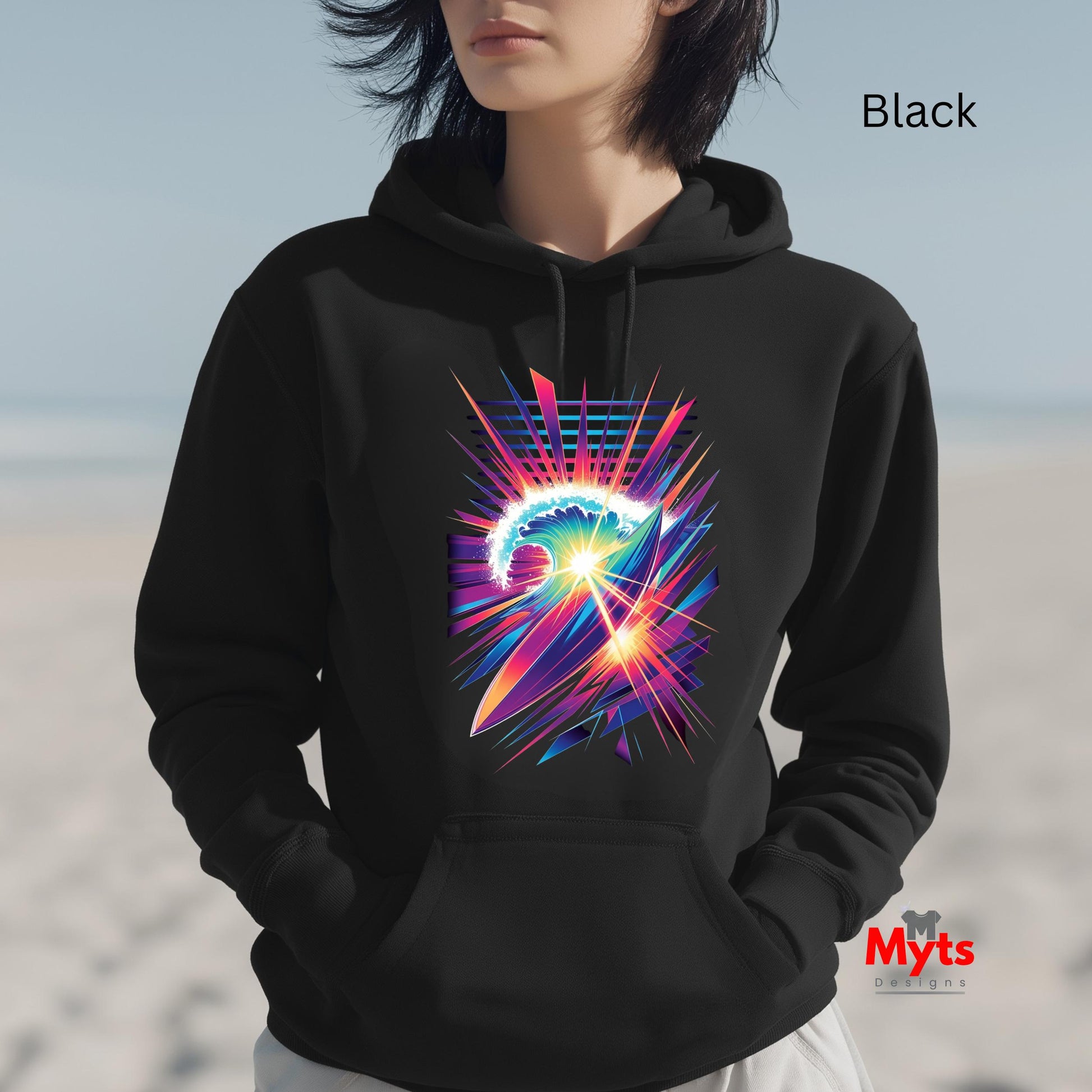 Person wearing a black hoodie with a colorful abstract design on a beach.