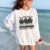 Person wearing a white sweatshirt with a graphic and text on a beach