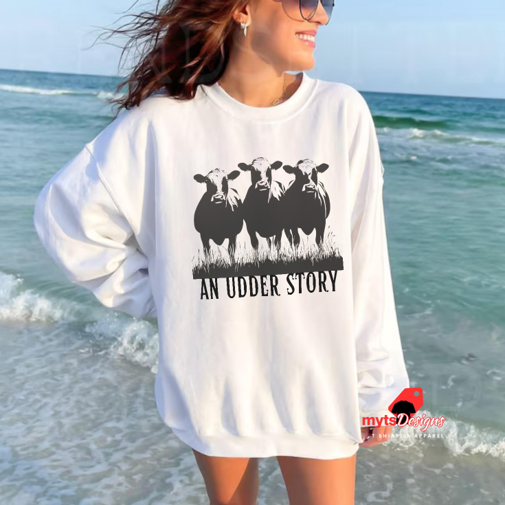Person wearing a white sweatshirt with a graphic and text on a beach