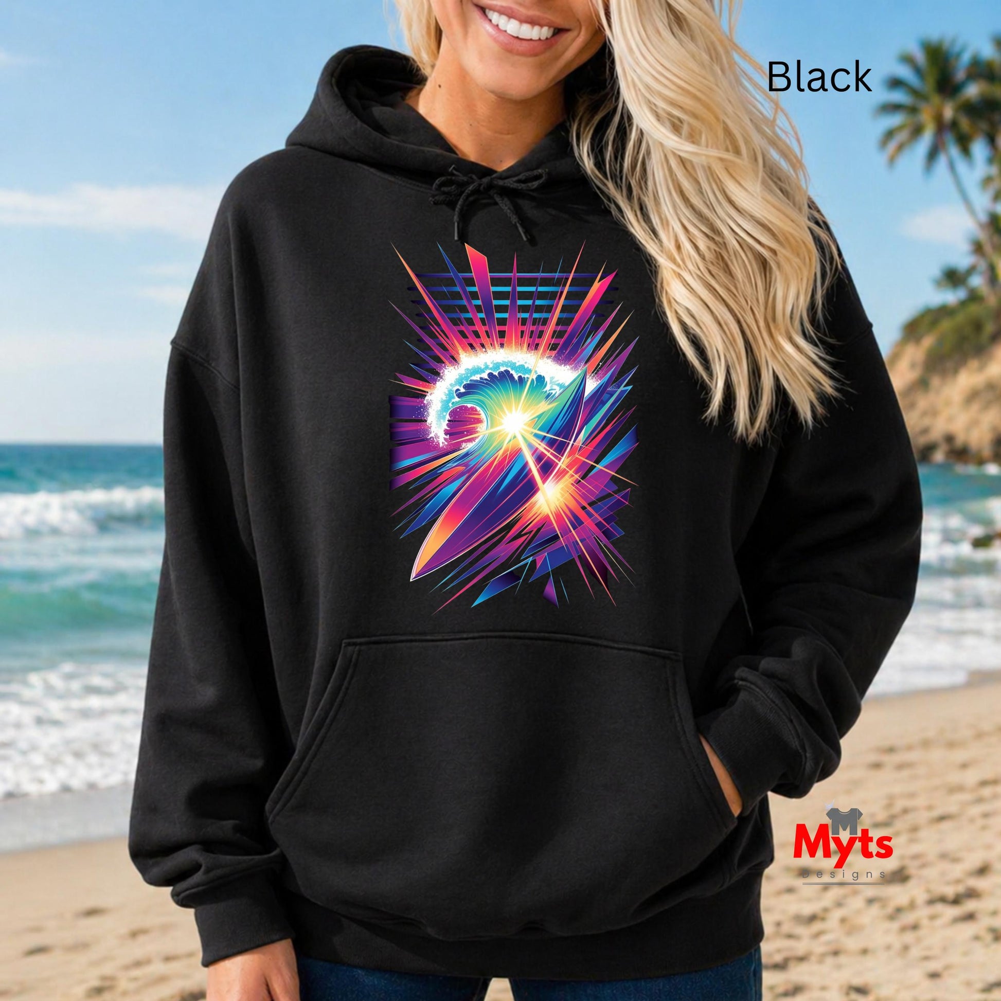 Person wearing a black hoodie with a colorful graphic design on a beach