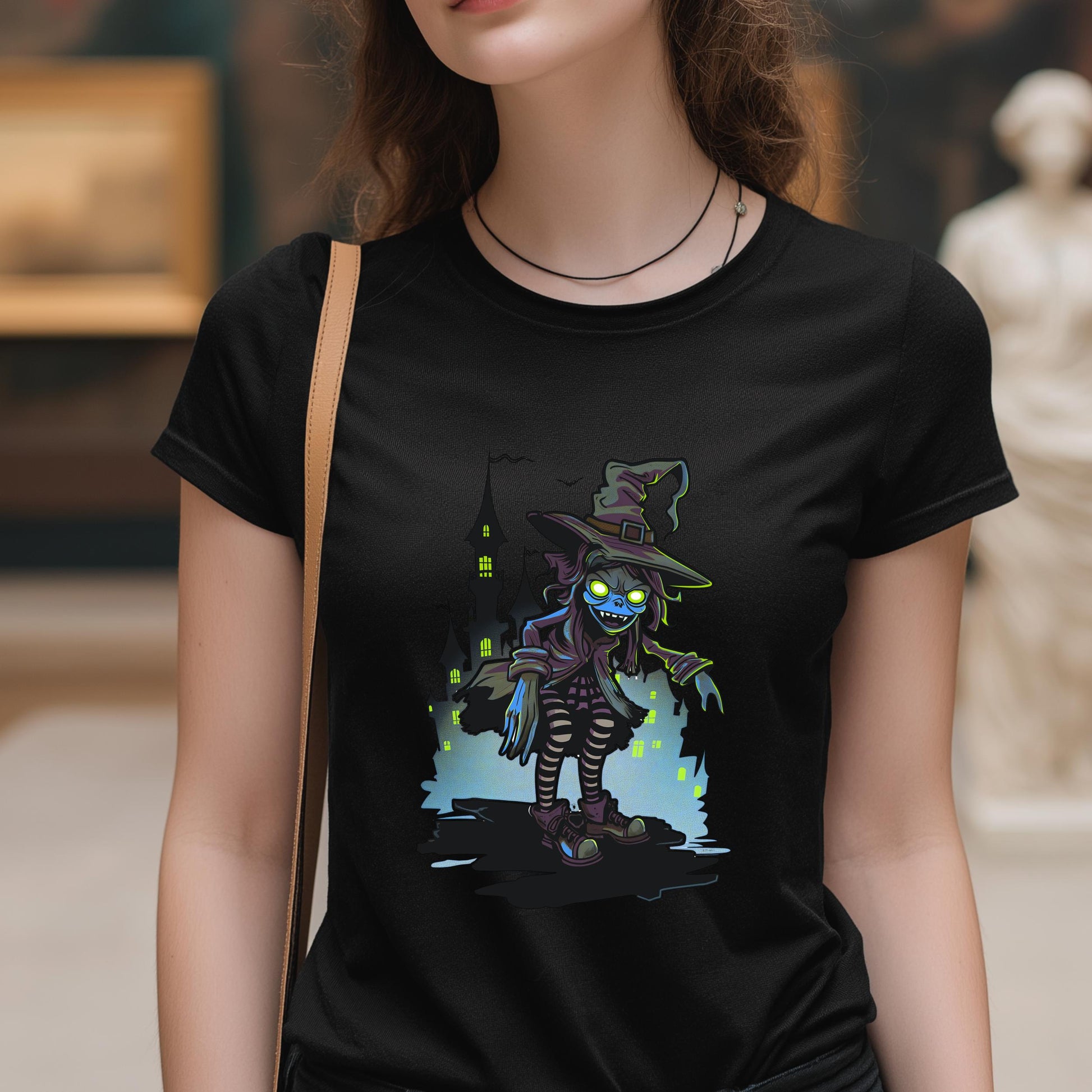 Person wearing a black t-shirt with a colorful graphic design of a witch.