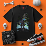 Black t-shirt with a witch graphic on an orange background with Halloween-themed items.