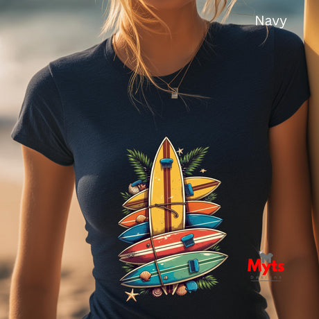 Person wearing a navy t-shirt with colorful surfboard design on a beach.
